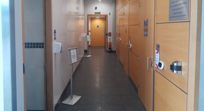 A level floored corridor with doors to toilets on either side.