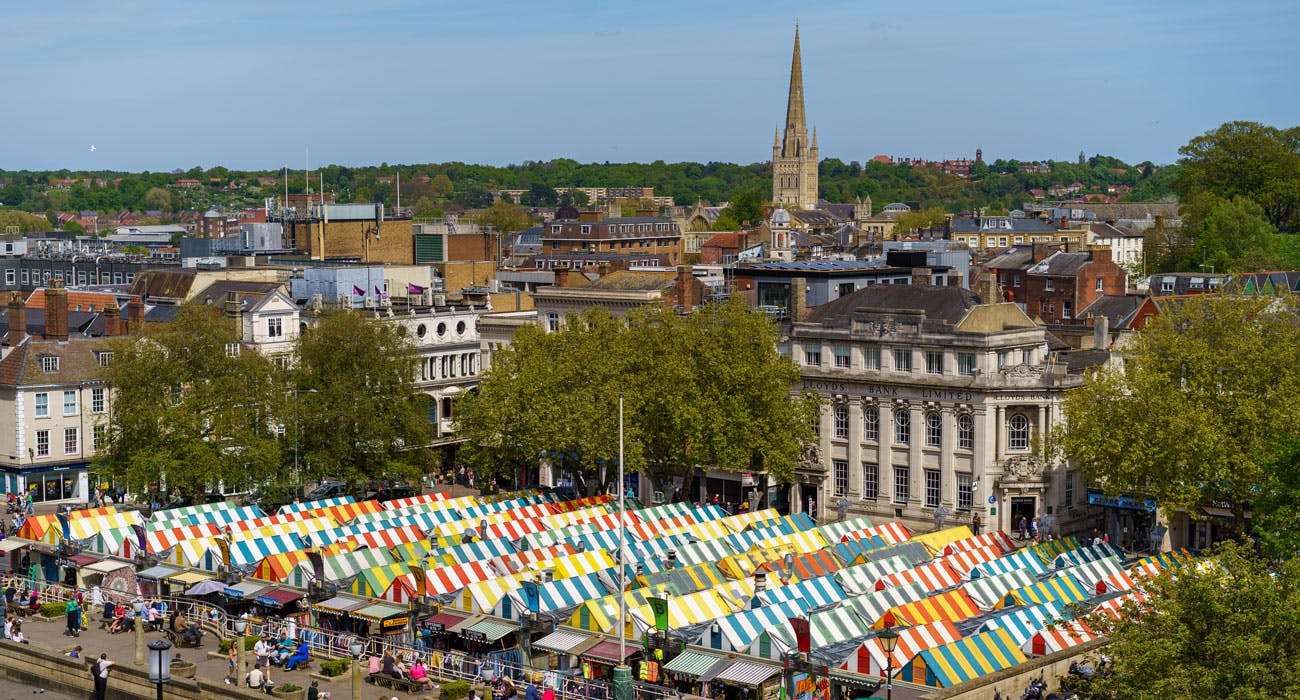 Norwich city centre, overlooking Norwich Market with it's colourful roofs and Norwich Cathedral in the distance.