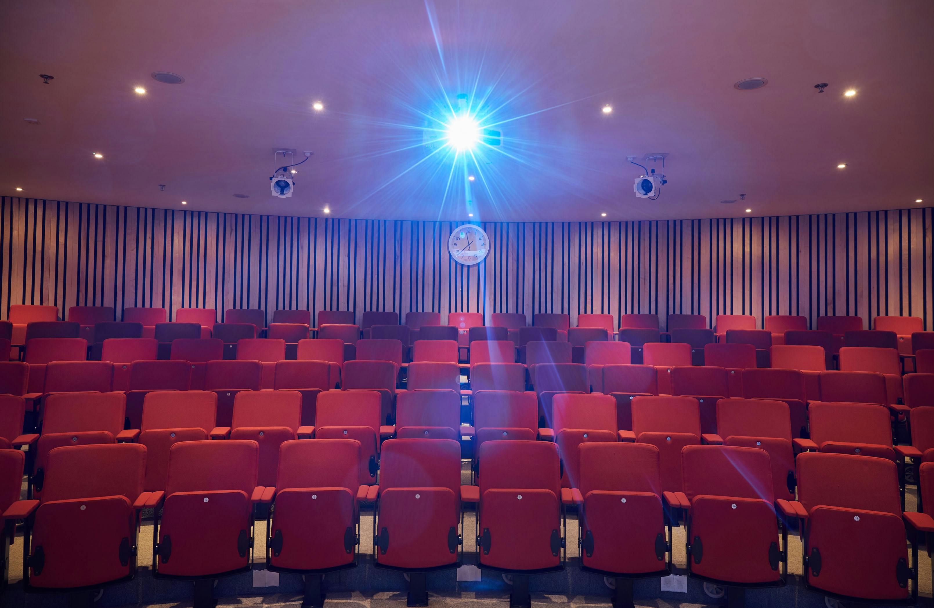 Theatre style tiered  seating with s bright projection light above.
