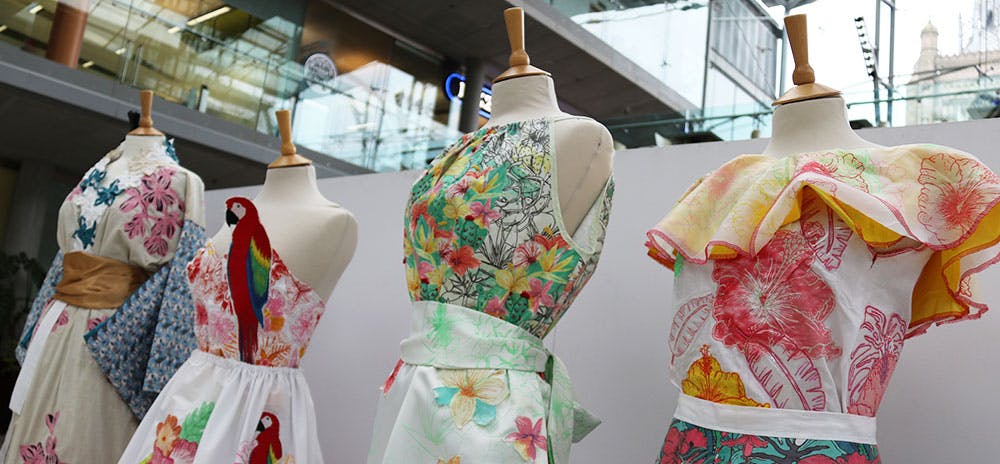 Four mannequins in a row with colourful, floral dresses on them inspired by retro designs