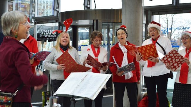 Members of Village Voices singing Christmas Carols