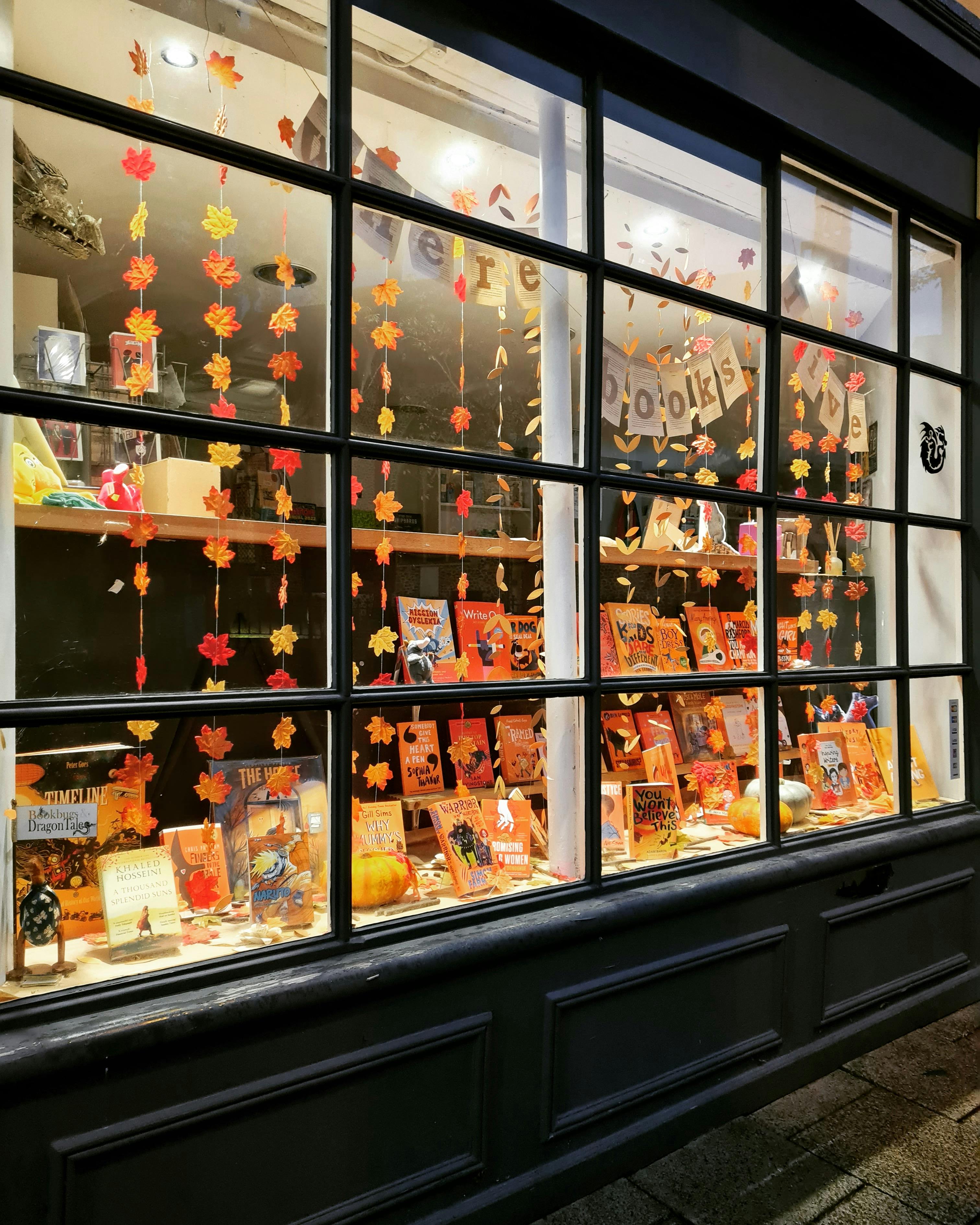 Bookbugs and Dragon Tales window decorated with autumn leaves.