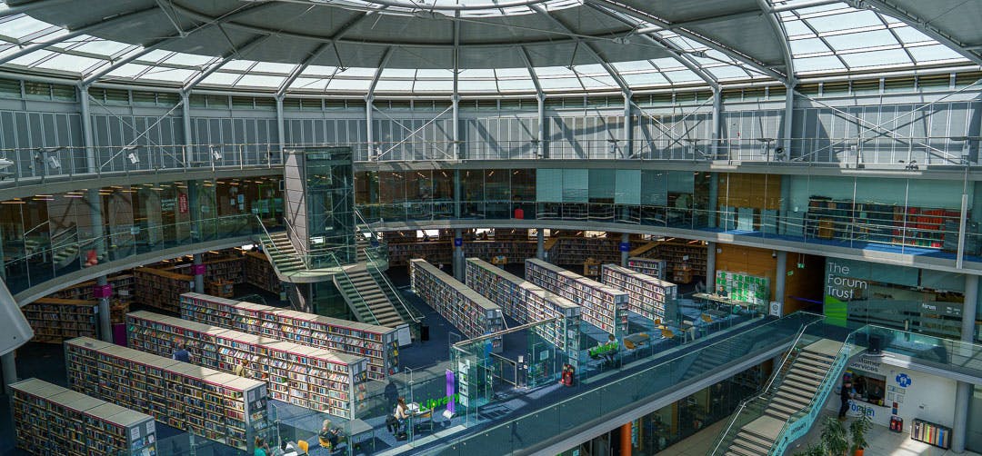 View of Millennium Library a modern building with lots of book stacks.
