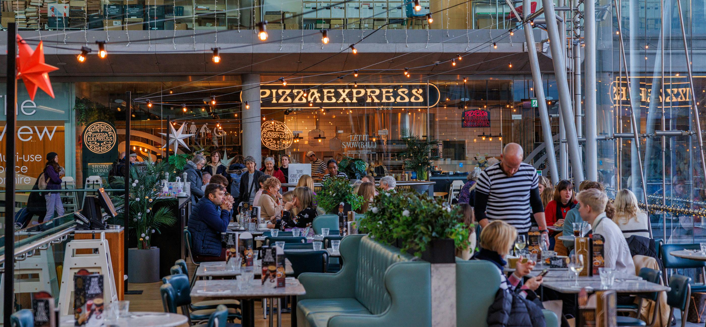 A busy Pizza Express restaurant with twinkling lights.