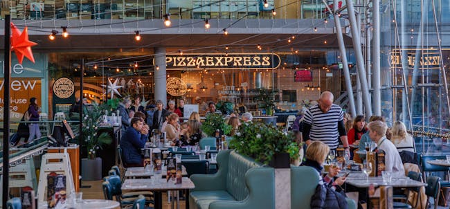 A busy Pizza Express restaurant with twinkling lights.