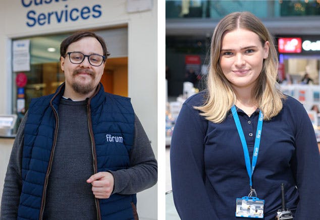 A man and women from the Customer Services team in navy blue uniforms with Forum logos on.