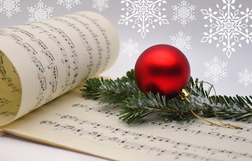 Sheet music with snowflakebackground and festive decorations.