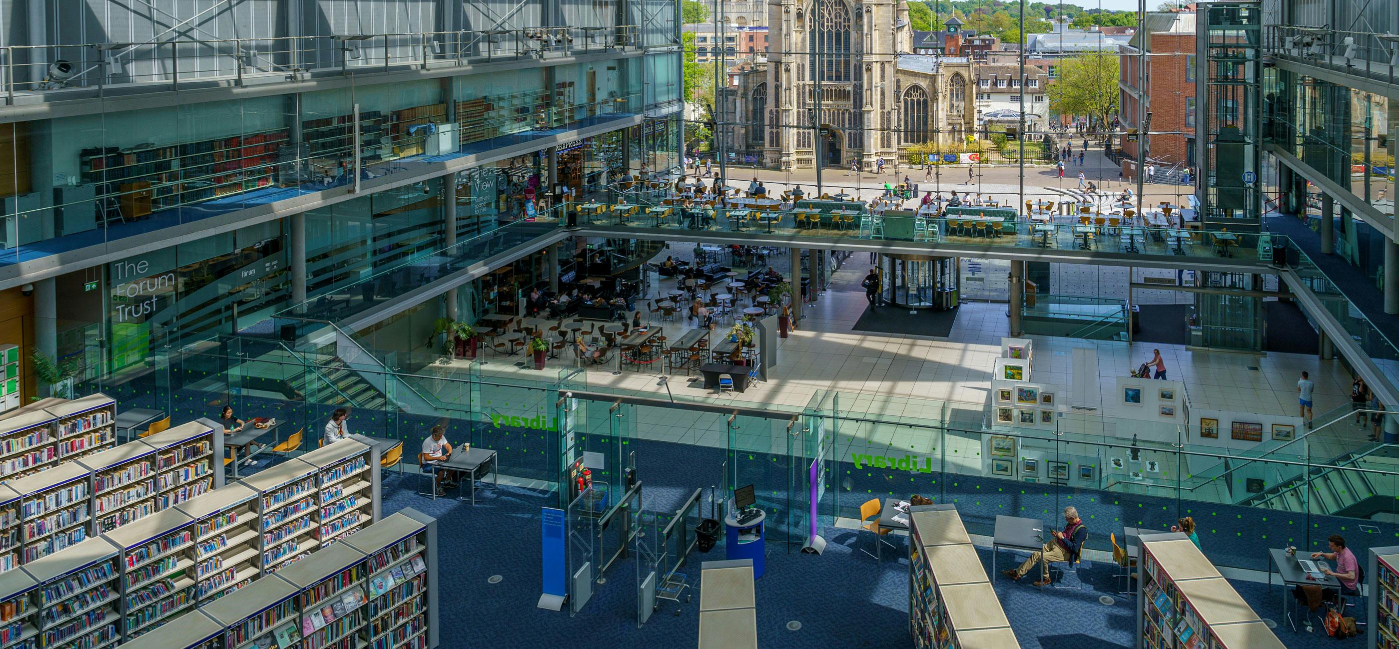 Looking down onto the First Floor of the Millennium Library, a modern building with glass frontage.