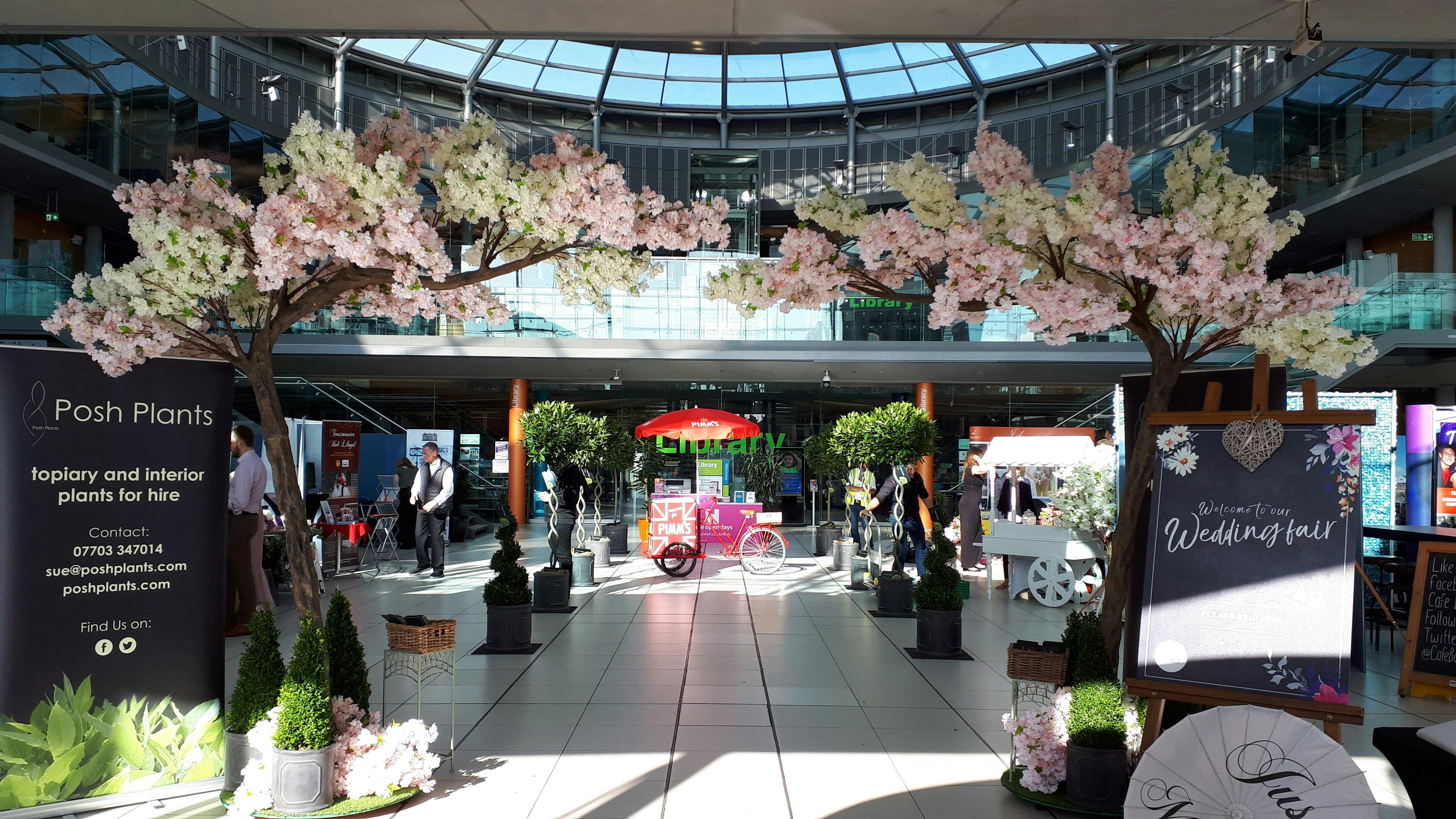 Artificial blossom trees and topiary bushes dress the entrance of The Atrium at The Forum Norwich.