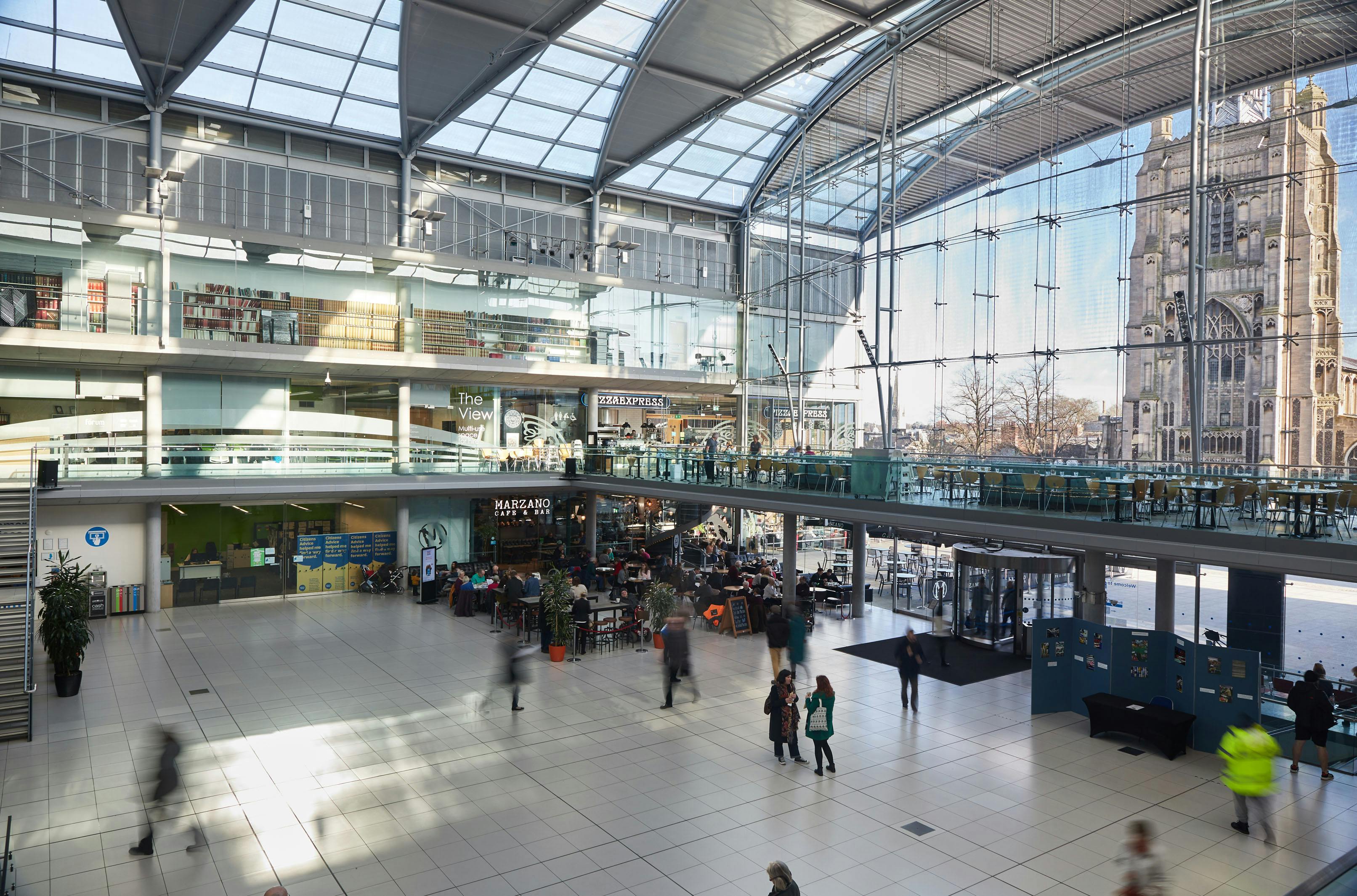 The Atrium space at The Forum Norwich, with white tiled floors and lots of natural light from the glass roof.