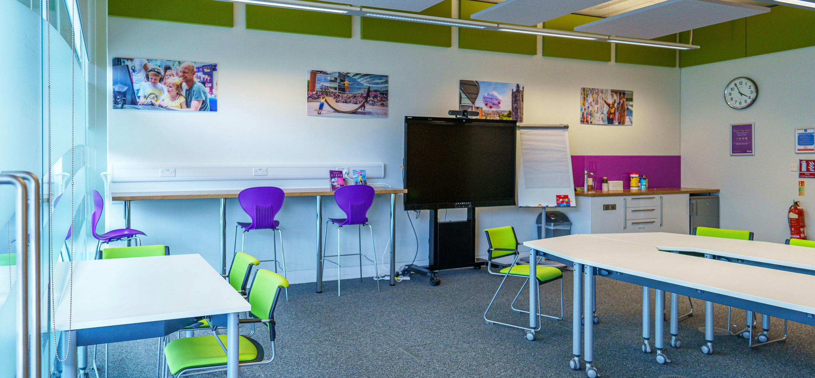 A modern meeting room with large Avocor interactive screen, tables and chairs.