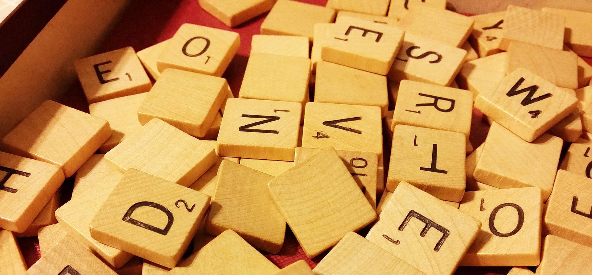 Wooden scrabble board game pieces with letters on.