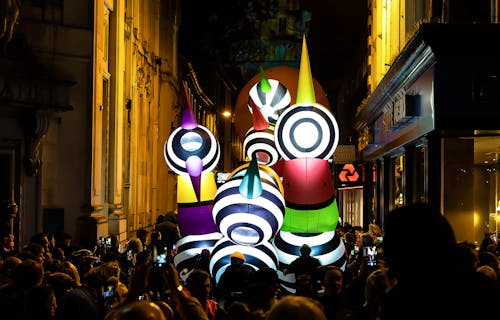 Colourful light-up inflatables are carried through the streets of Norwich at night, lighting up the crowd gathered around.