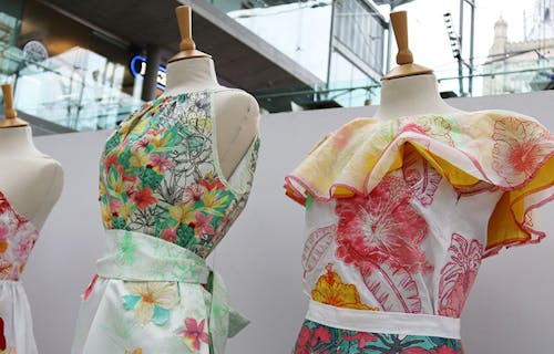 Four mannequins in a row with colourful, floral dresses on them inspired by retro designs