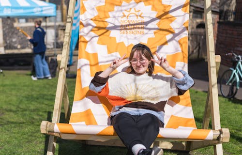A girl smiles in a giant deck chair listening to a live band.