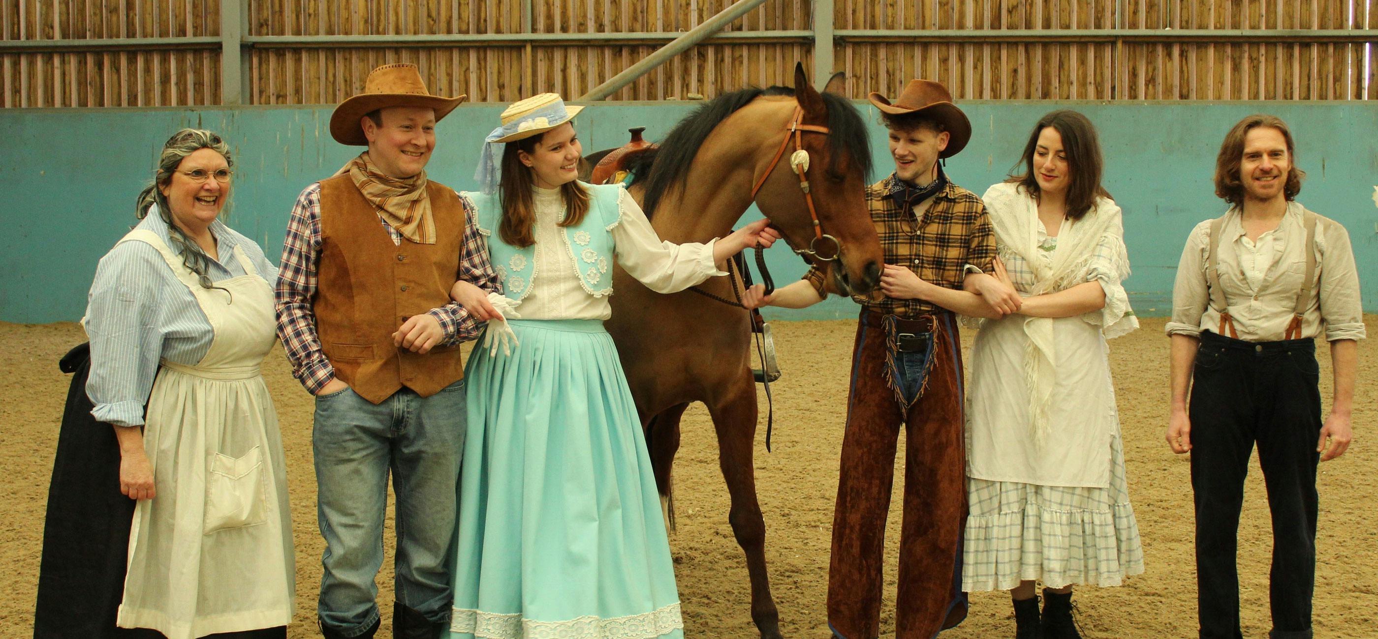 Oklahoma cast dressed like cowboy style with a horse