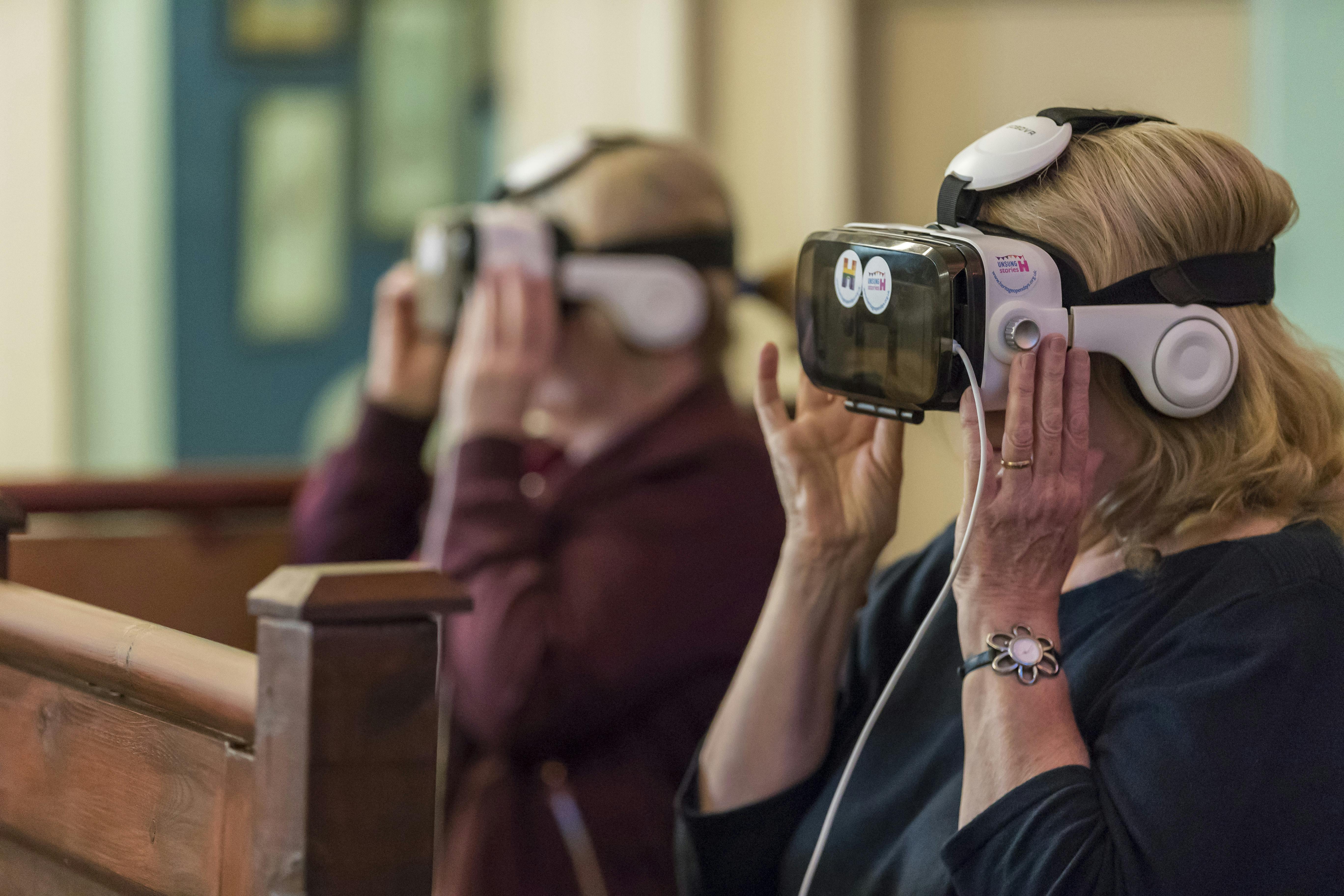 People viewing an event through Heritage Open Days branded VR goggles
