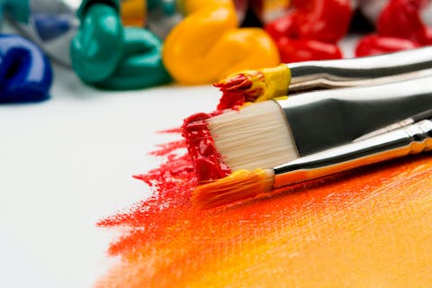 paintbrushes and brightly coloured paints