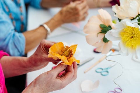 Hands arranging flowers made of paper