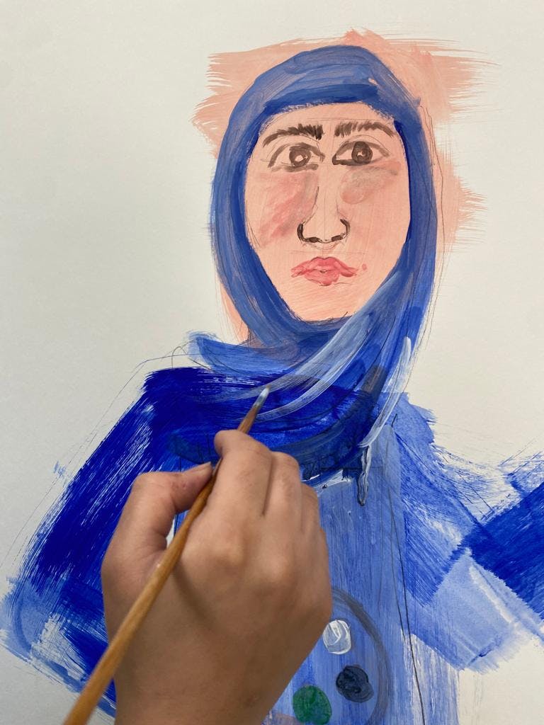 Woman's hand painting a portrait