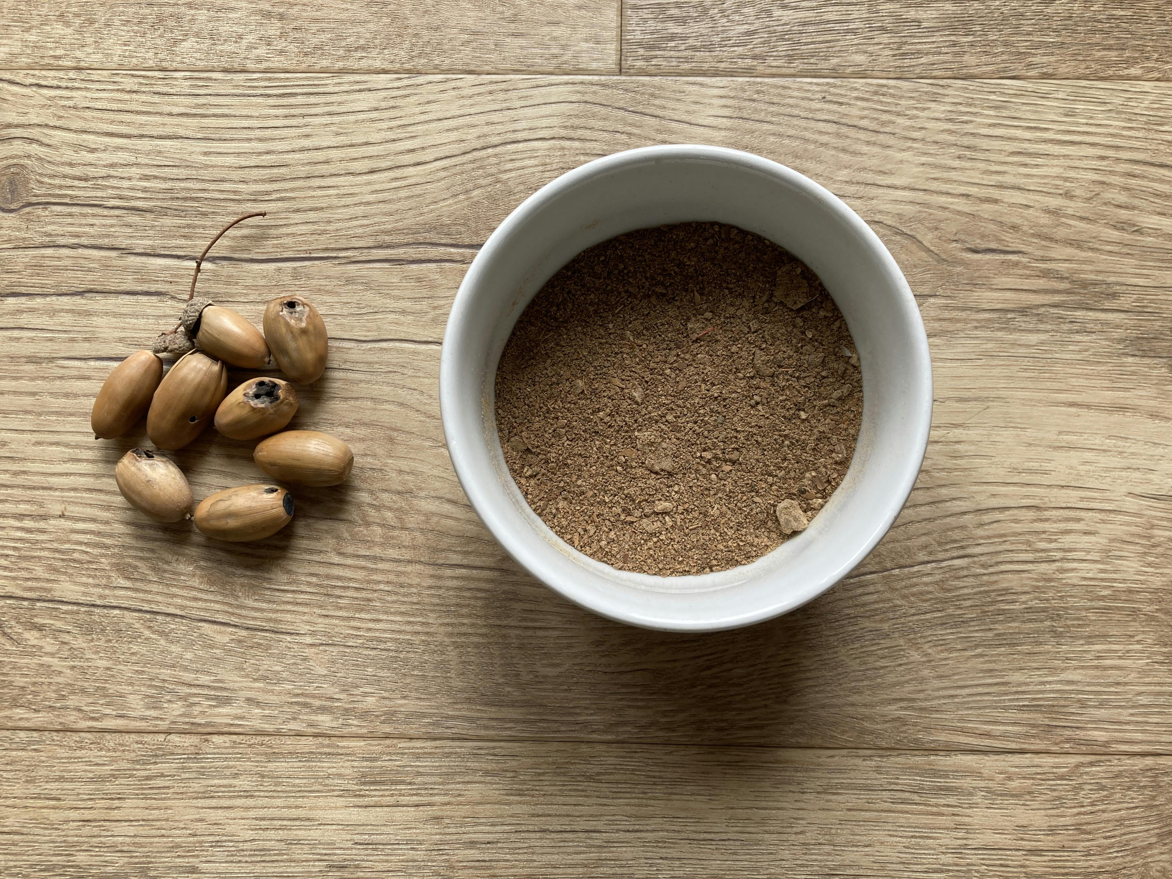 acorns and coffee grounds on a wooden surface