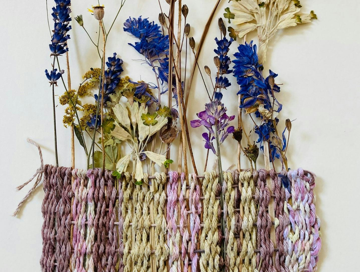 Weaving with flowers and dyed threads.