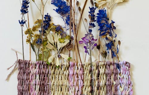 Weaving with flowers and dyed threads.