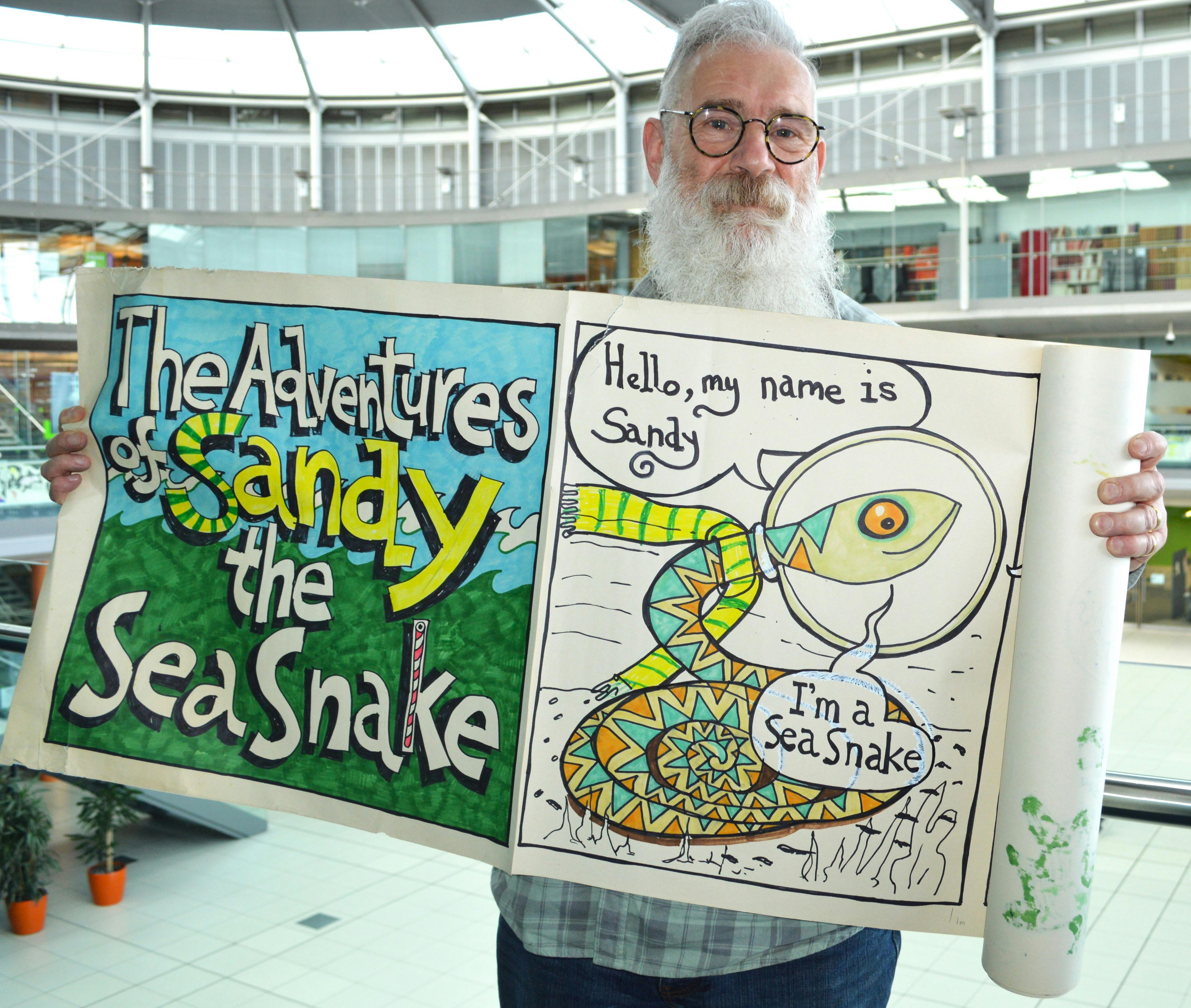 Man holding large scale cartoon on roll of paper.