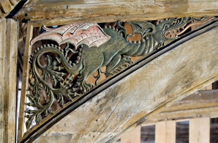 Close up of a carved dragon in a wooden roof arch