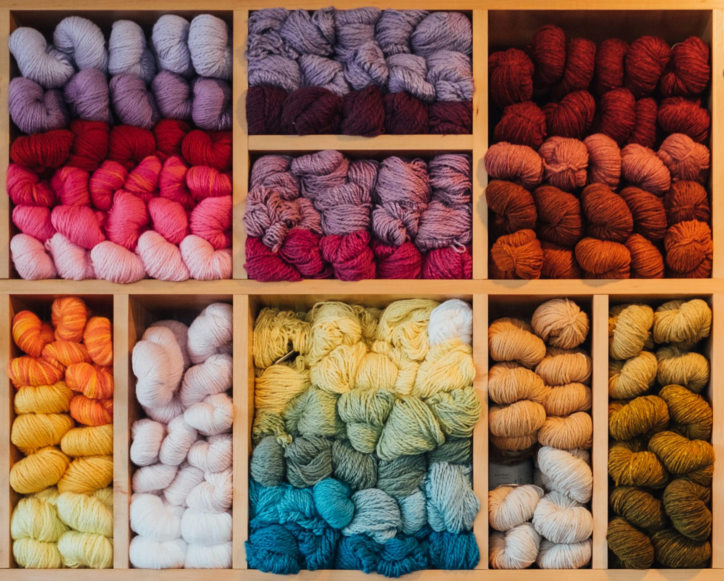 Wooden box full of different colours of yarn