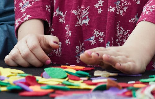child's hands and coloured craft materials