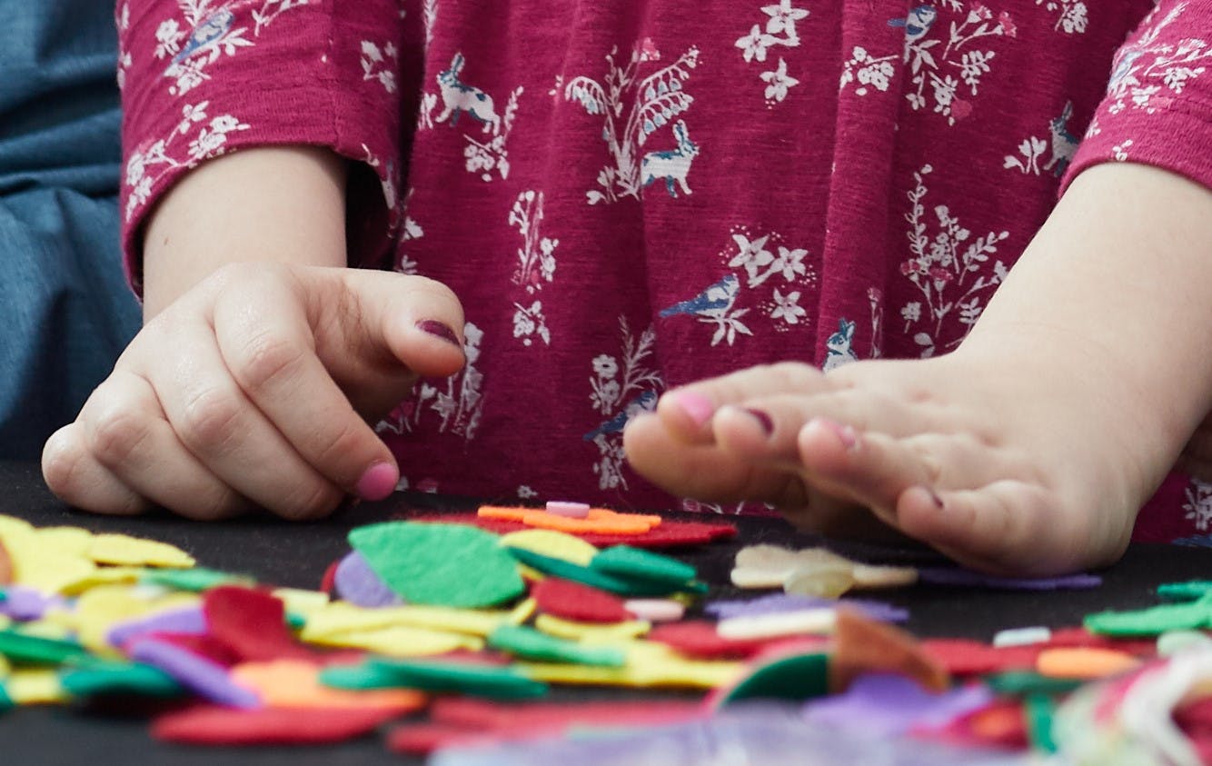 child's hands and coloured craft materials