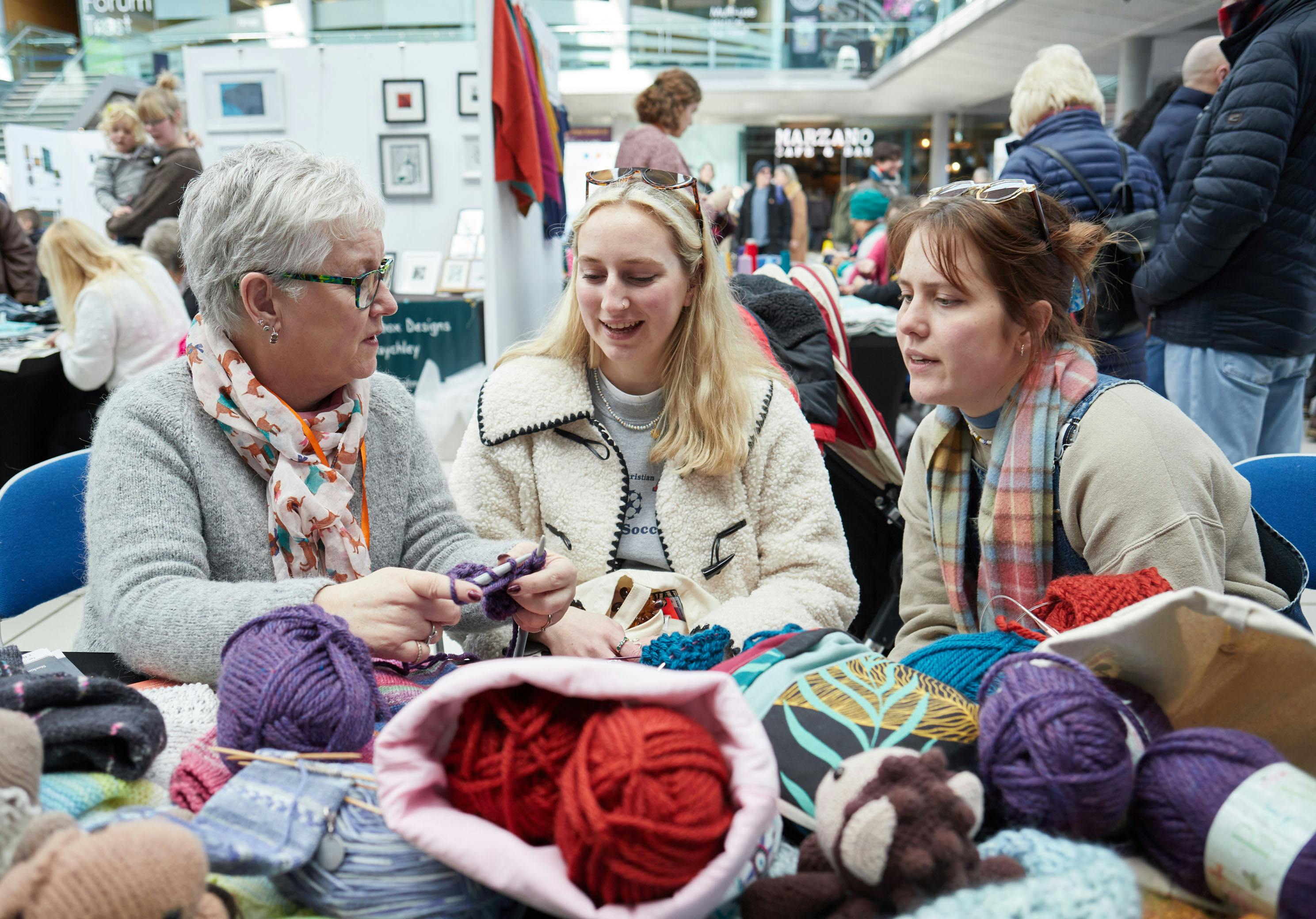 Three women discussing knitting