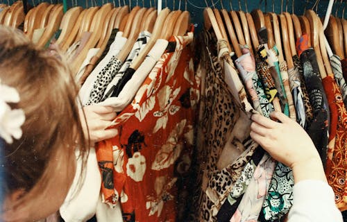 A woman looks through a rail of vintage clothes.