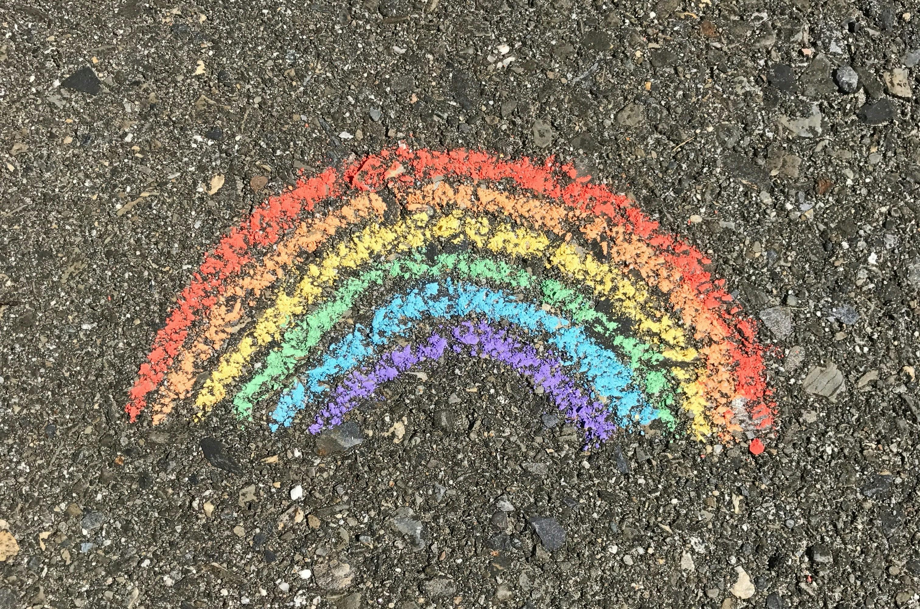 A rainbow drawn with coloured chalk on concrete