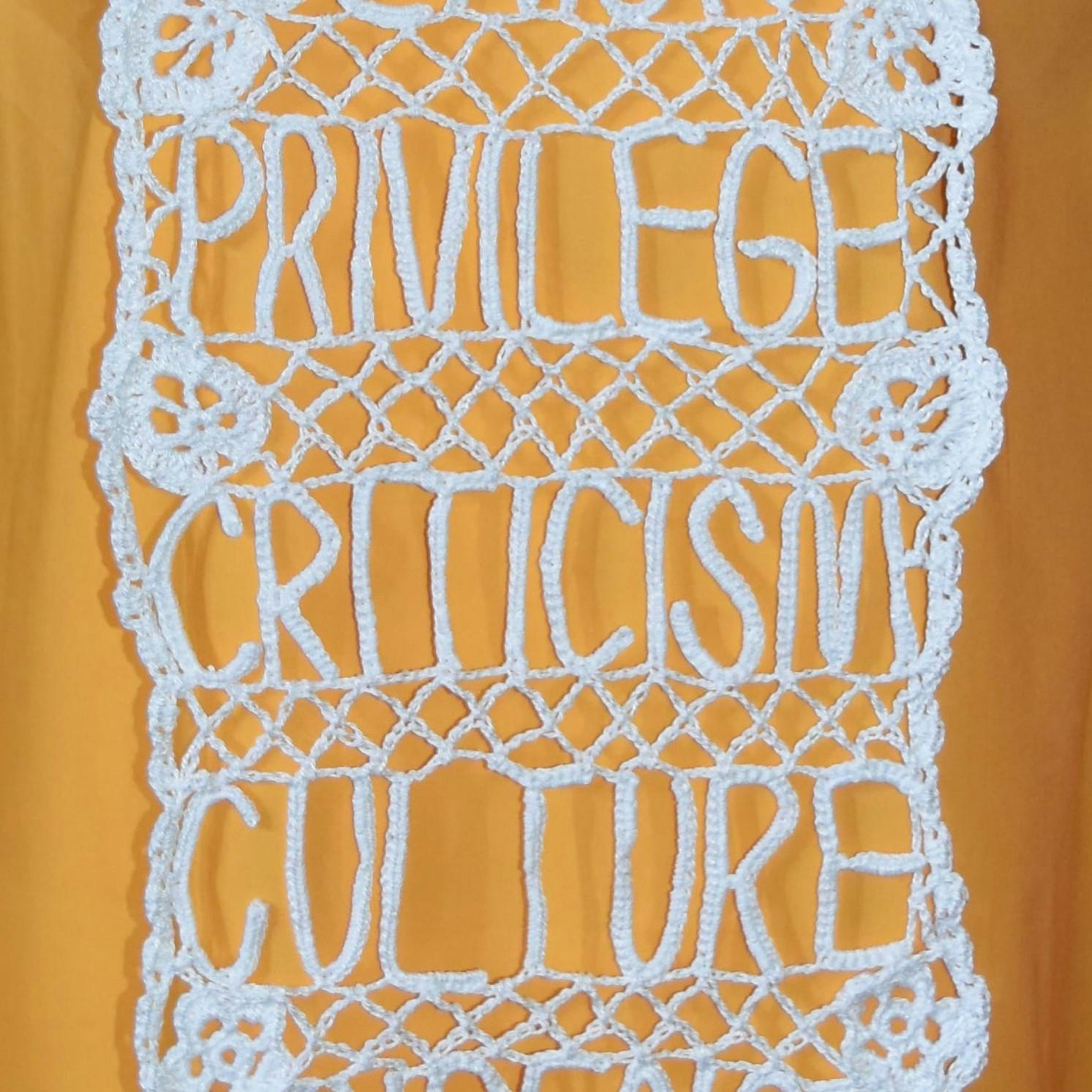 Close up of crochet lace with wording 'Privilege, Criticism, Culture' on