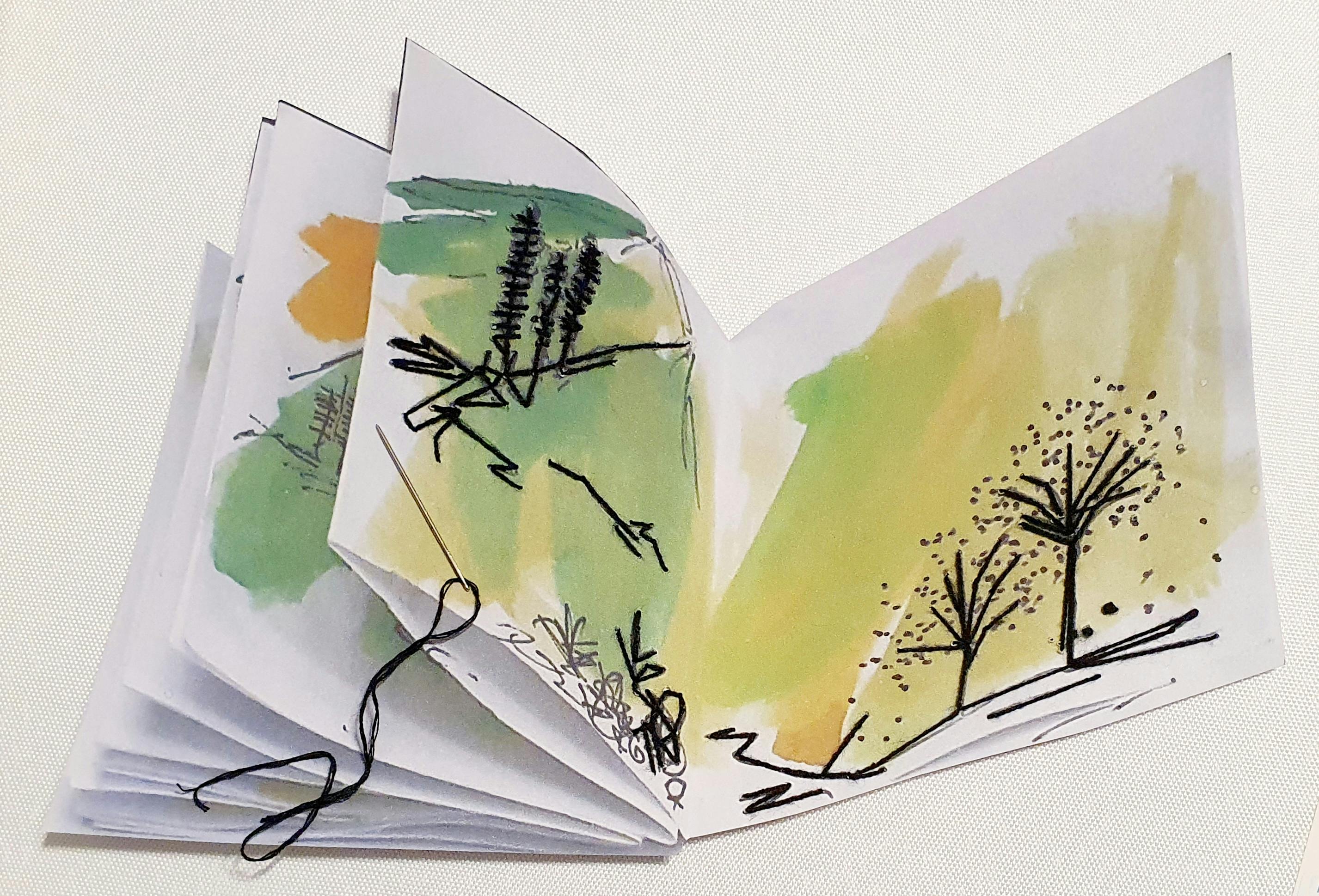 paper folded  into a book shape with pain and stitch patterns