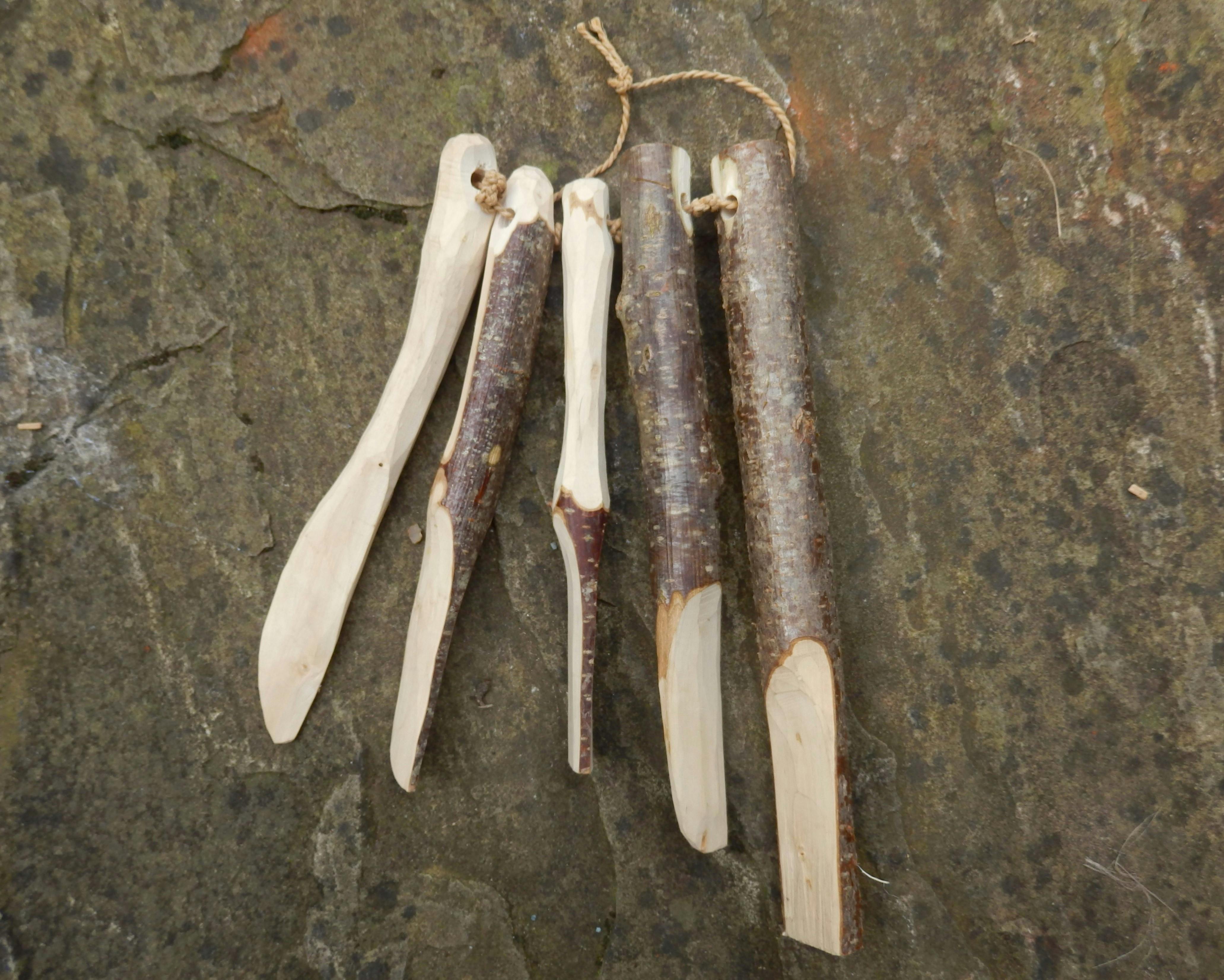 Five sticks in stages of being made into a knife
