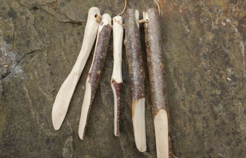 Five sticks in stages of being made into a knife