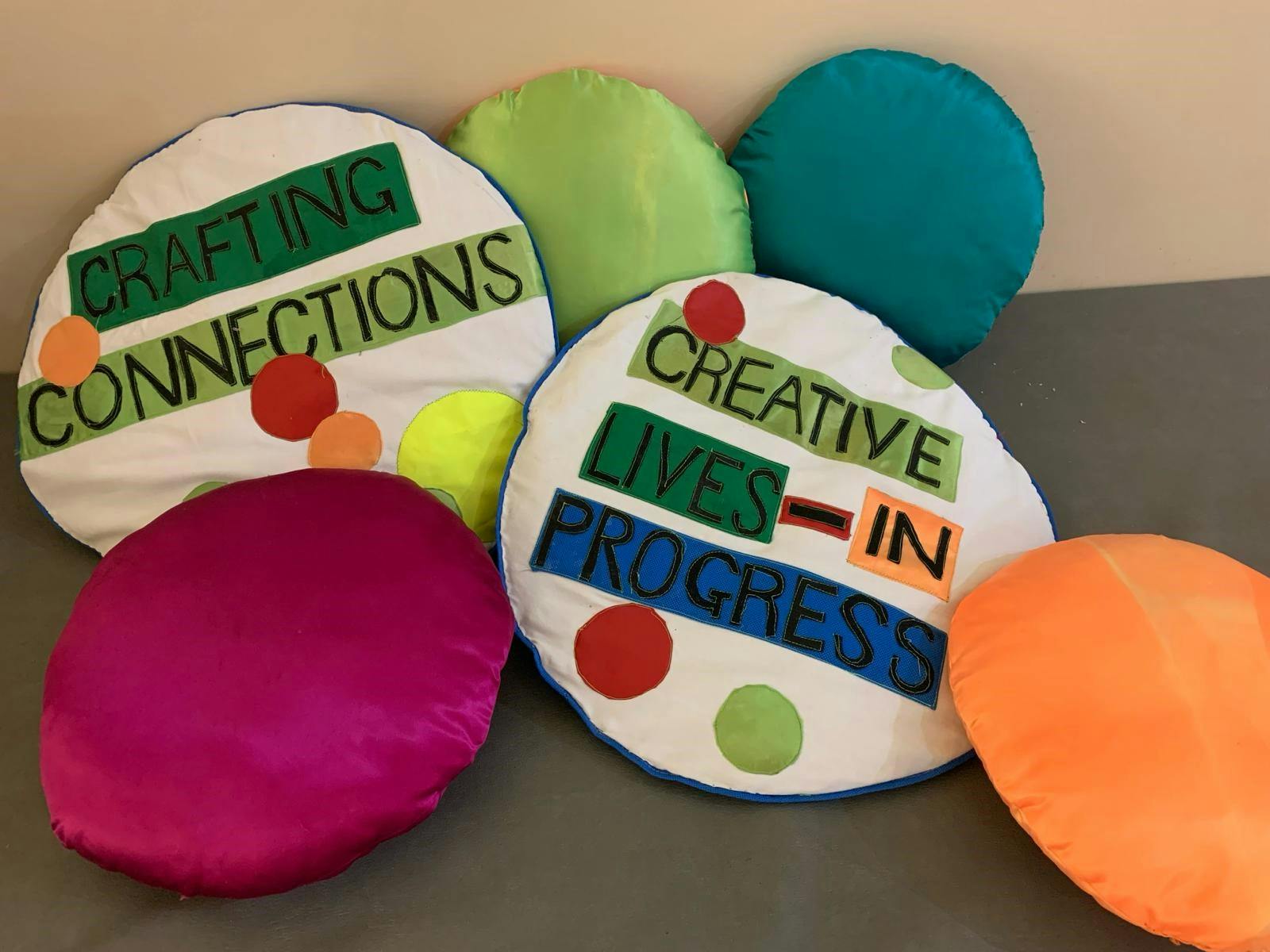 coloured cushions... two with the words CREATIVE LIVES IN PROGRESS