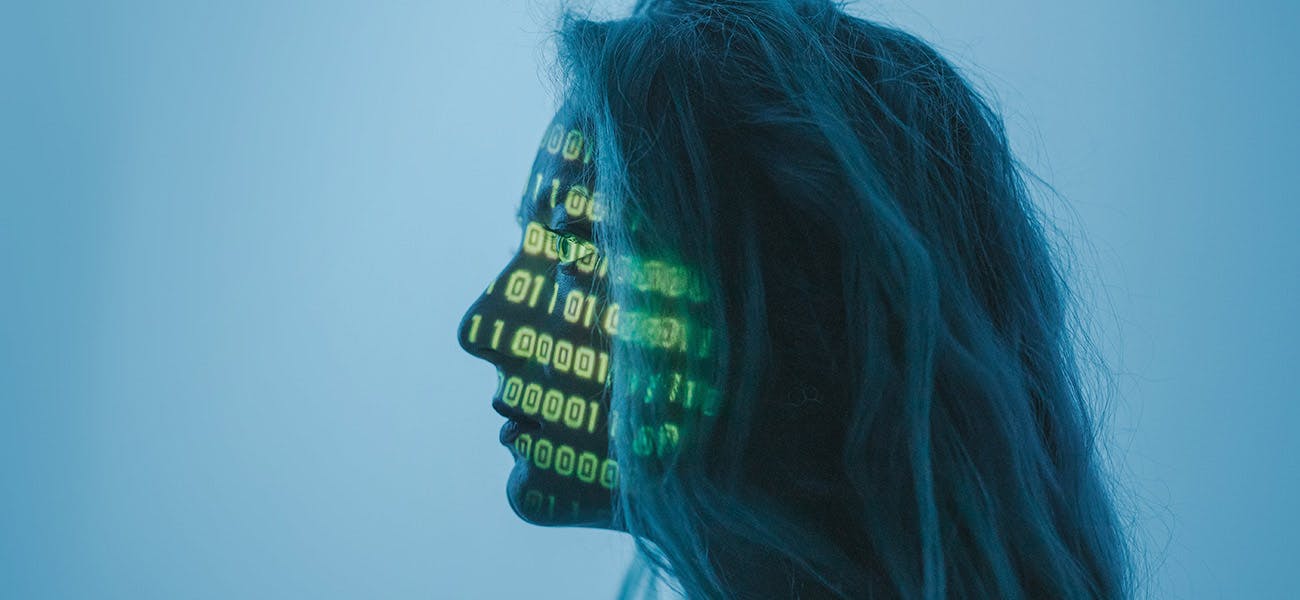 A woman with long hair and binary code projected on to her face