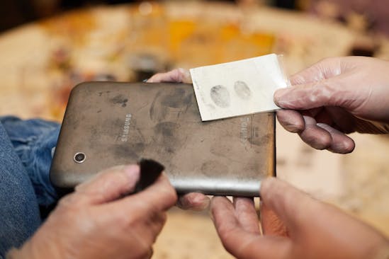 Two people study fingerprints at a forensic murder mystery event