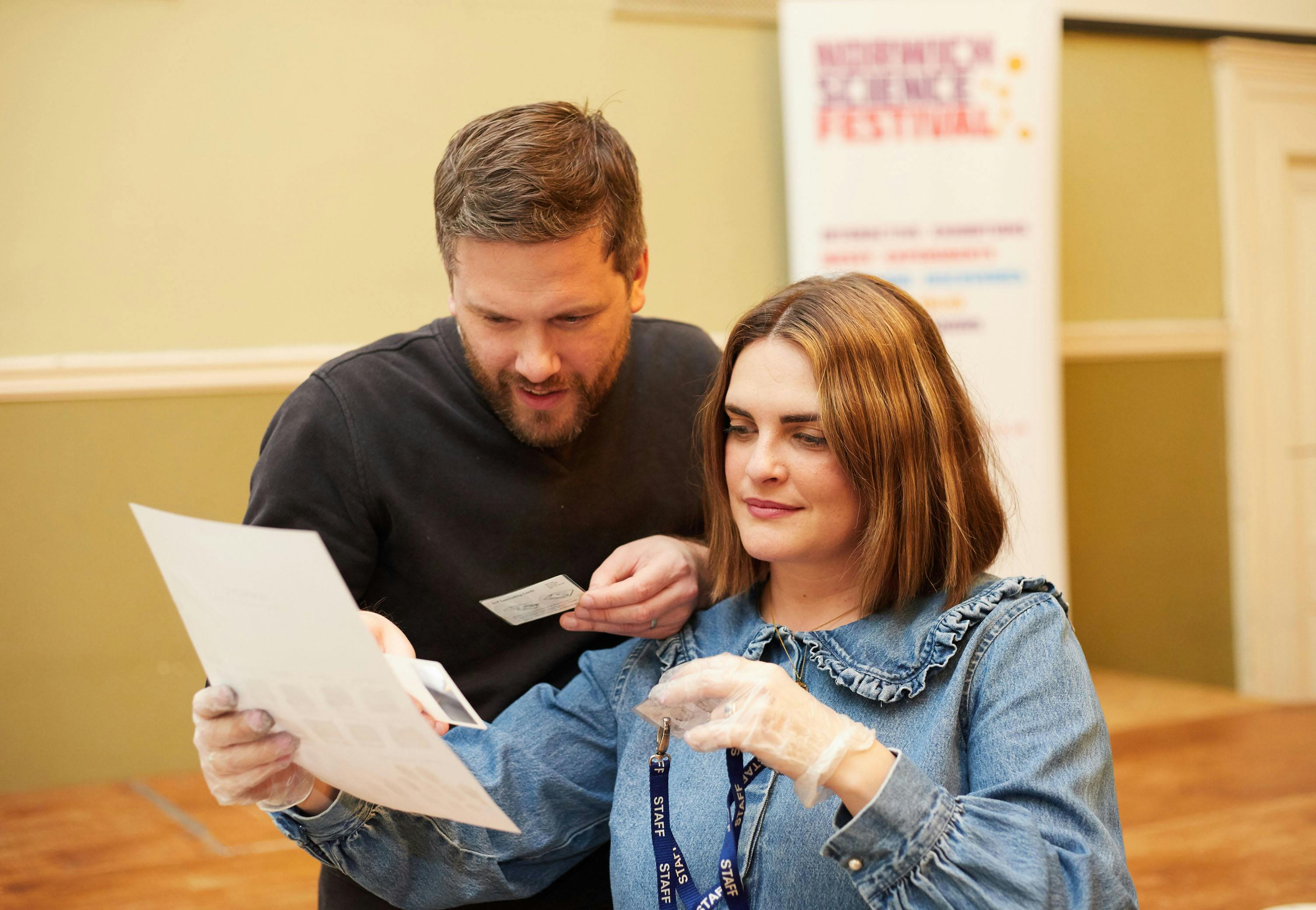 Two people study fingerprints at a forensic murder mystery event