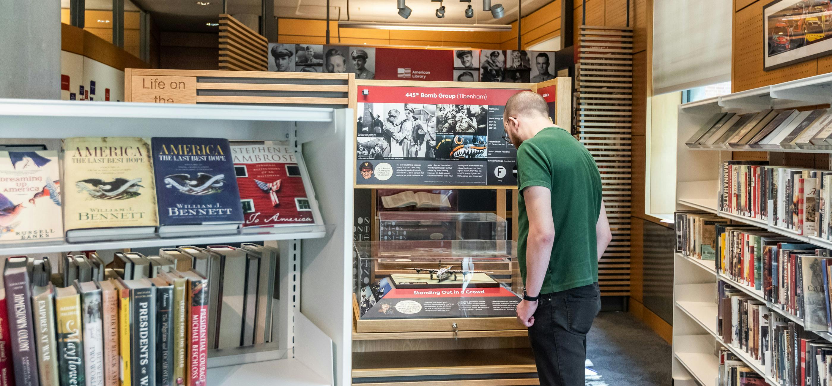 A man looks at a model airplane display in the American Library.