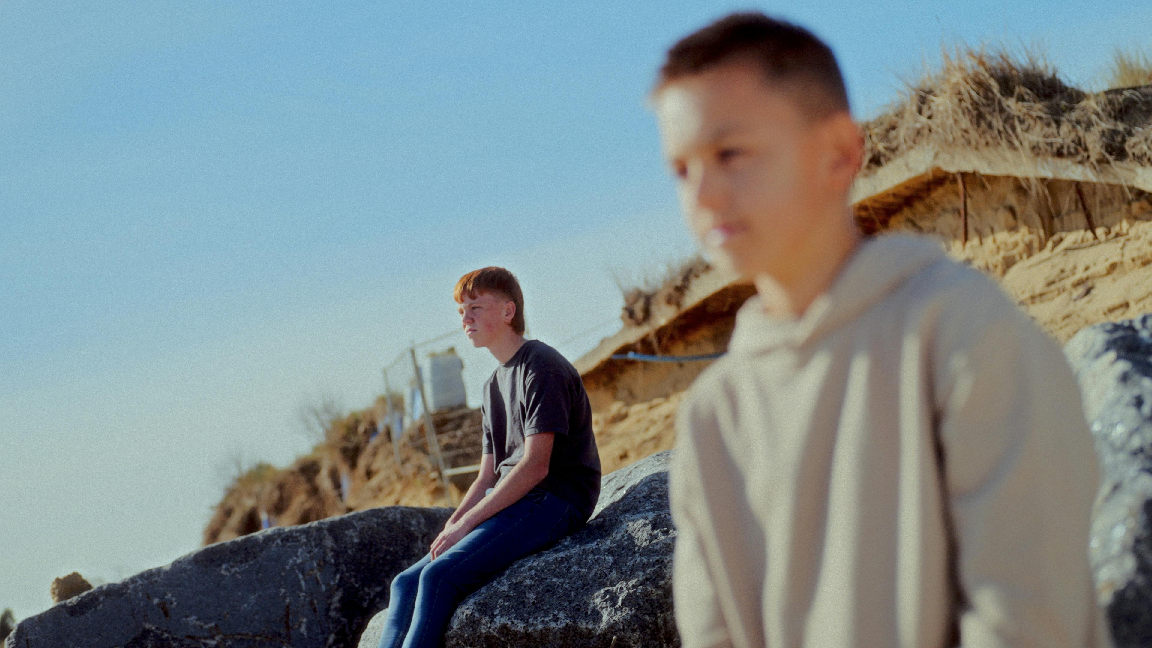 Two boys sitting and looking out.