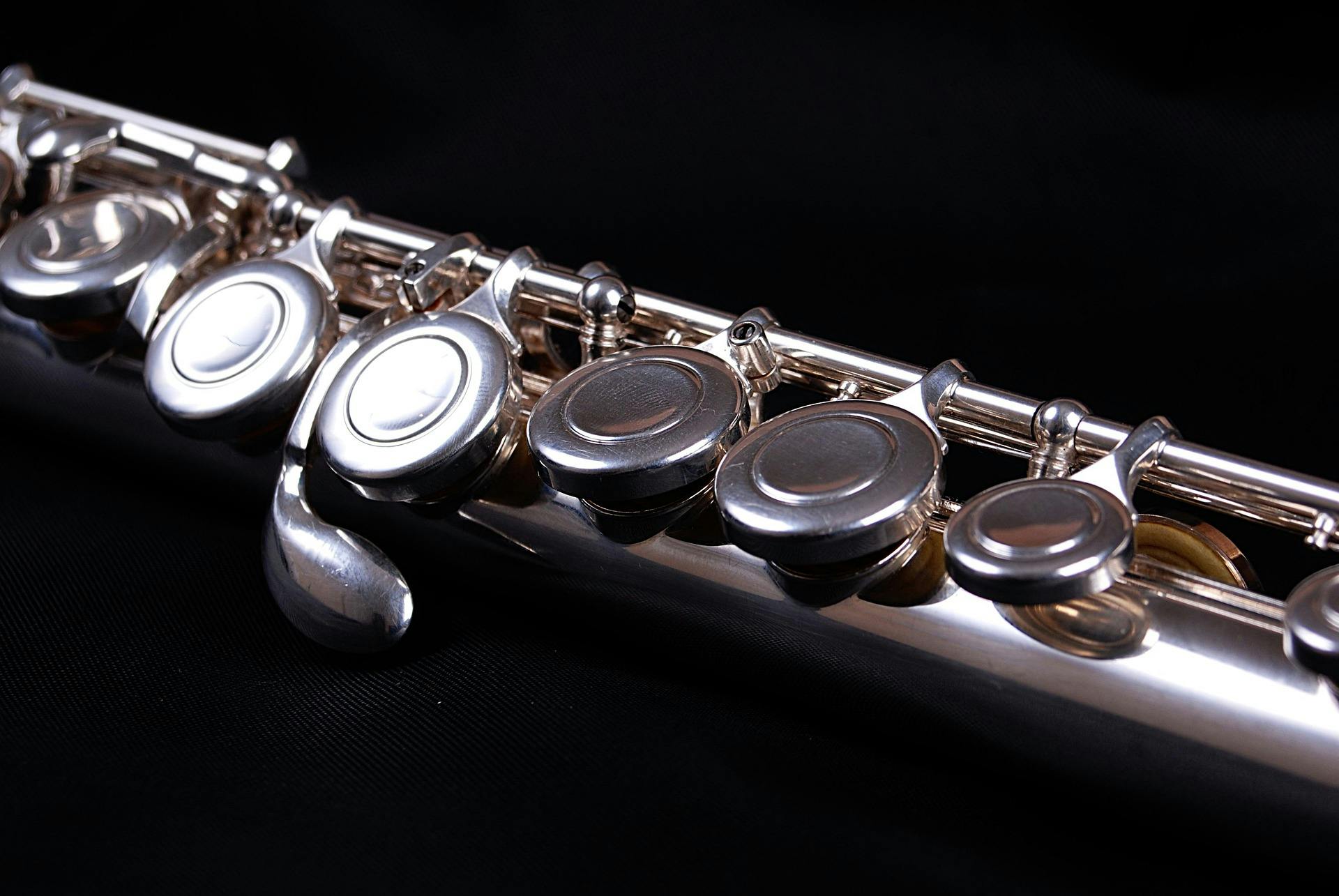 Close up of a flute against a black background.