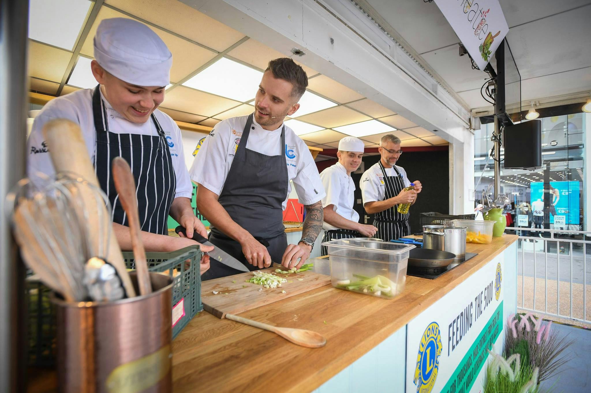 Chefs preparing food in a feeding the 5000 trailer