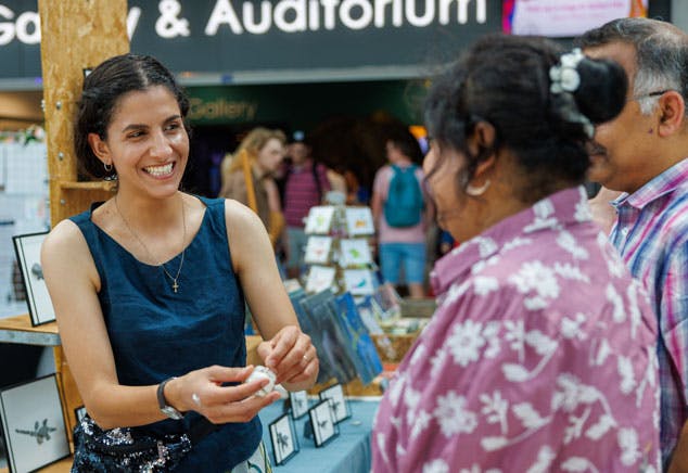 A stall holder smiles at customers at The Forum