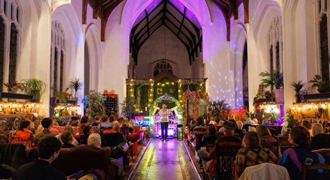 An old church, with high ceiling, lit with colourful lights