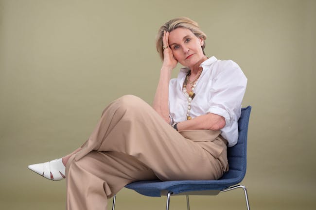 Mark Portas sitting on a chair with her leg crossed